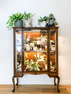 a wooden cabinet with plants on top of it