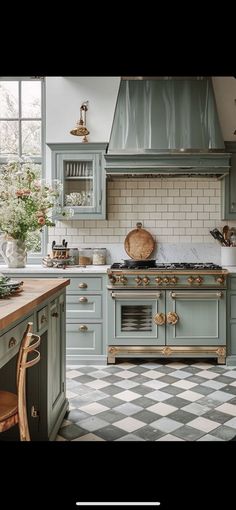 a kitchen with green cabinets and checkered flooring on the floor, along with an oven