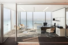 an office with glass walls overlooking the water