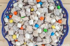 a blue bowl filled with marshmallows on top of a wooden table