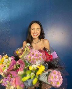 a woman is holding a bouquet of flowers