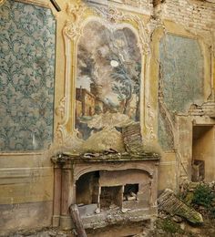 an old fireplace in the middle of a room with paintings on the walls and ceiling