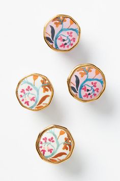 three decorative knobs with floral designs on the front and back, sitting next to each other