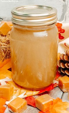 a jar filled with liquid sitting on top of a table next to some pine cones