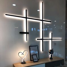 a white wall with some lights on it and a wooden table in front of it