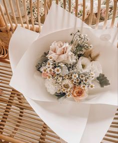 a bouquet of flowers sitting on top of a white paper wrapped in some kind of wrapping