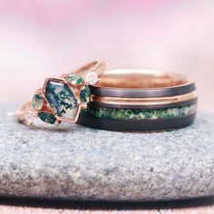 three rings with different designs on them sitting on top of a rock