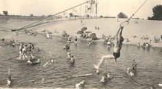 an old black and white photo of people in the water with one person jumping into the water