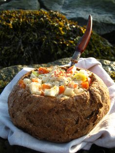 a bread with cheese and carrots on it sitting on a towel next to some rocks