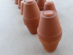 several brown vases are lined up on the ground