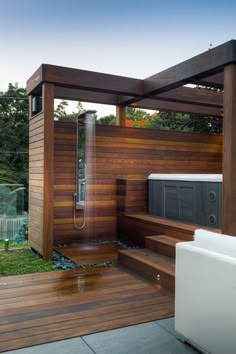 an outdoor shower in the middle of a wooden decked area with a hot tub