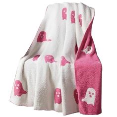 a pink and white blanket with skulls on it