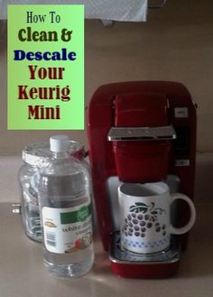 a red coffee maker sitting on top of a counter next to a bottle of water