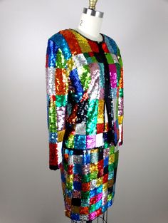 "This is a VIBRANT mini skirt and blazer set! Both are beautifully detailed with multicolored sequins and beading all over in a retro color block grid or checkered design. Both pieces are in perfect condition! Blazer Bust - will fit up to 40\" bust Shoulders - 18\" Sleeves - 23\" Length of Blazer - 23\" Waist of Skirt - 26-28\" Hips - 36-42\" Length of Skirt - 19\" All of my items come from a pet-free and smoke-free home. If you would like more info or have any questions, please don't hesitate t Vintage Patchwork Dresses For Party, Multicolor Fall Party Sets, Fall Party Multicolor Sets, Multicolor Party Sets For Fall, Retro Party Sets For Spring, Retro Patchwork Dress For Party, Fitted Embellished Multicolor Sets, Fitted Multicolor Embellished Sets, Fitted Multicolor Evening Sets