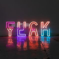 the word flick yeah is lit up in neon colors and stands against a dark background