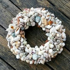 a wreath made out of seashells sitting on top of a wooden table