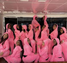 a group of women in pink outfits posing for a photo