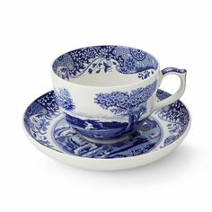 a blue and white cup and saucer set on a white background with an ornate design