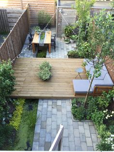 an outdoor patio with wooden decking and seating area, surrounded by plants and trees