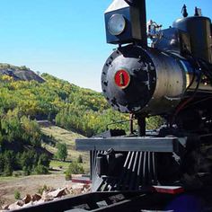 an old fashioned train traveling through the mountains