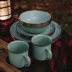 a table topped with plates and cups next to a lantern