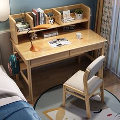 a wooden desk and chair in a small room with blue walls, hardwood flooring and white curtains