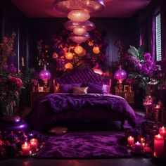 a bed with purple comforter surrounded by candles