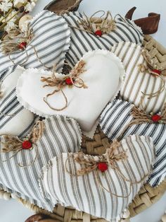 a heart shaped pillow sitting on top of a woven basket filled with fabric and twine