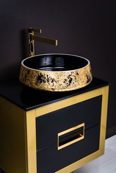 a black and gold sink on top of a cabinet