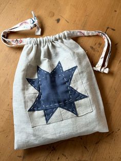 a small bag with a blue star on it sitting on top of a wooden floor