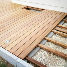 a close up of a wooden deck with steps leading to the side of a house