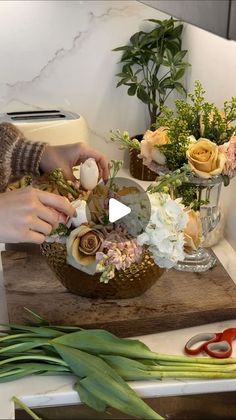 a woman is cutting flowers on a wooden board