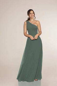 a woman in a green dress posing for the camera with her hands on her hips