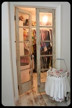 an open door leading to a closet with clothes on hangers