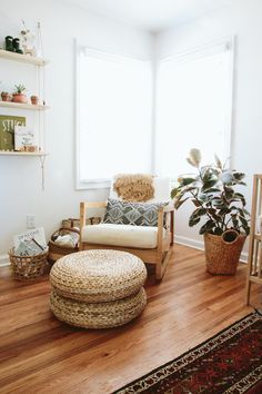 a living room filled with furniture and a potted plant next to a large window