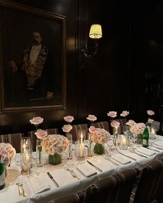 a long table is set up with flowers and candles for a formal dinner or function