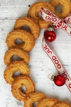 some onion rings and a christmas ornament on a white wooden surface with a red ribbon