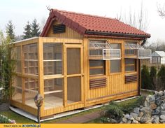 a small wooden building sitting on top of a lush green field