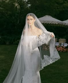 a woman in a wedding dress with a veil on her head