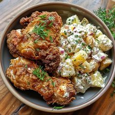 a bowl filled with fried chicken and potatoes