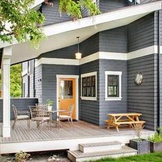 a blue house with white trim and wooden deck