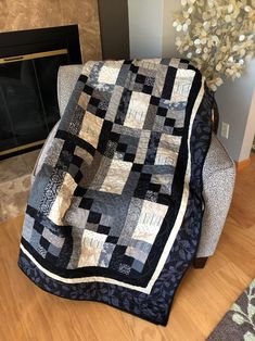 a black and white quilt sitting on top of a chair next to a fire place