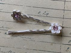 Two pretty vintage 90's bobby pins with pearly white and purple flowers Lovely vintage bobby pins - two exactly the same - cute pearly white flowers/daisies with purple crystal centres. In good unused vintage condition - from a collection of genuine vintage unused stock from the 1990's -  perfect gift for any vintage lover. Vintage Hair Pin, Cute Bobby Pins, White And Purple Flowers, Vintage Fashion 90s, Hair Bobby Pins, Flowers Daisies, Vintage Hair Clips, Sanya, Purple Crystal