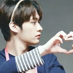 a young man making a heart with his hands