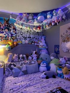 a bed with lots of stuffed animals on it and lights hanging from the ceiling above