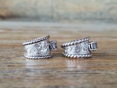 two silver rings sitting on top of a wooden table