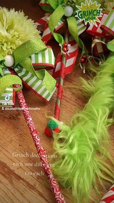 two green and red christmas bows with candy canes on a wooden table next to flowers