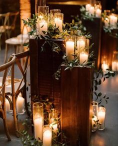 candles and greenery are arranged on top of an old wooden box for the centerpiece