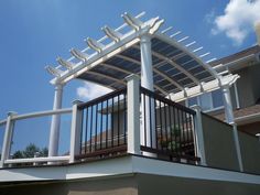 a white pergolan on top of a building with blue sky in the background