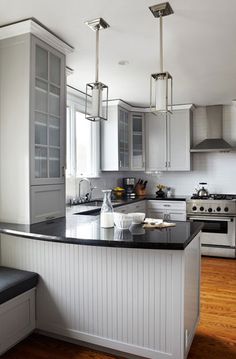 an image of a kitchen with white cabinets and black counter tops in the center island